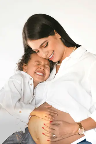 Mamá embarazada abrazando a su hijo sonriente