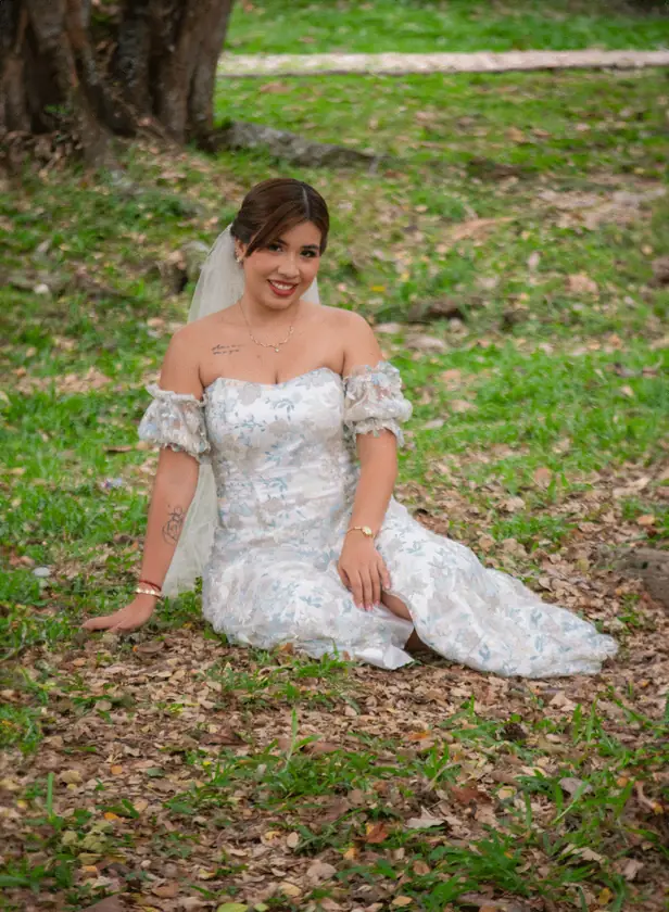 Novia sentada sobre el césped con su vestido