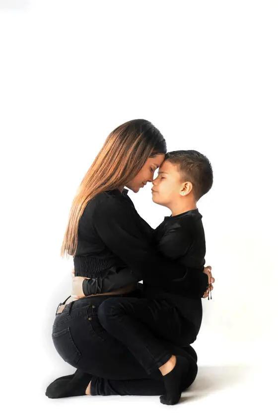 Mamá abrazando a su hijo frente a frente en estudio