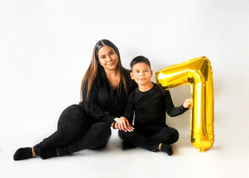 Mamá e hijo celebrando los 7 años con globo dorado
