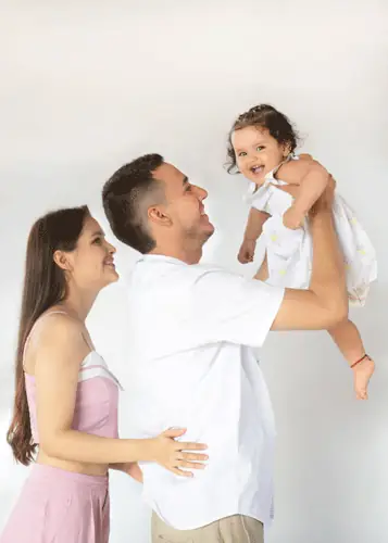 Familia en estudio: papá levanta a su bebé