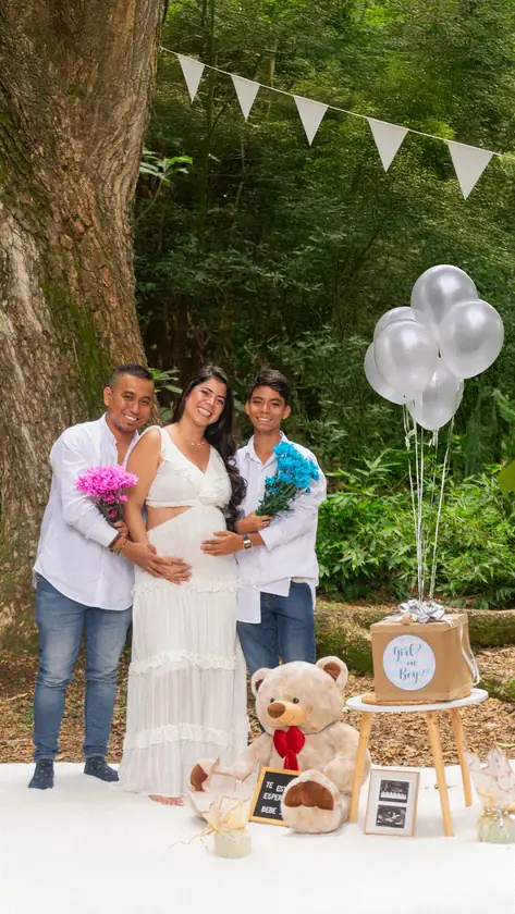 Revelación de género en familia con globos y peluche