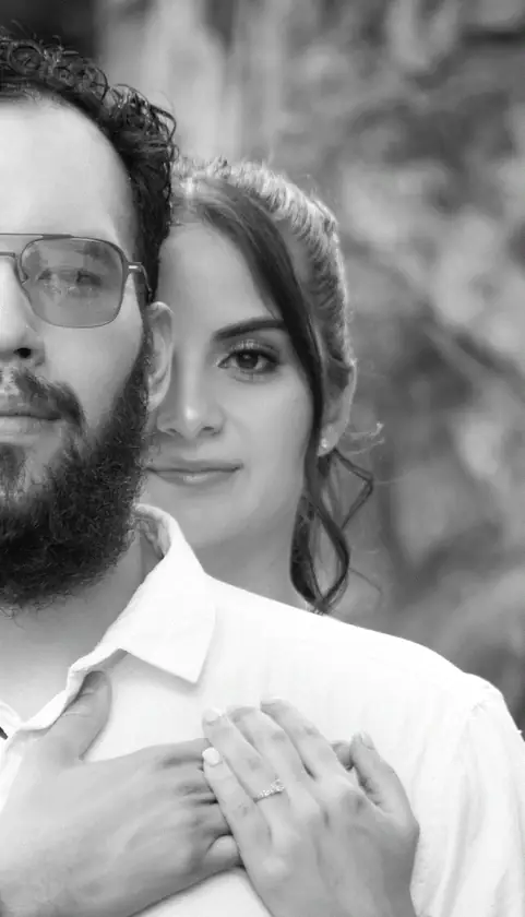 Pareja abrazada en blanco y negro mostrando el anillo